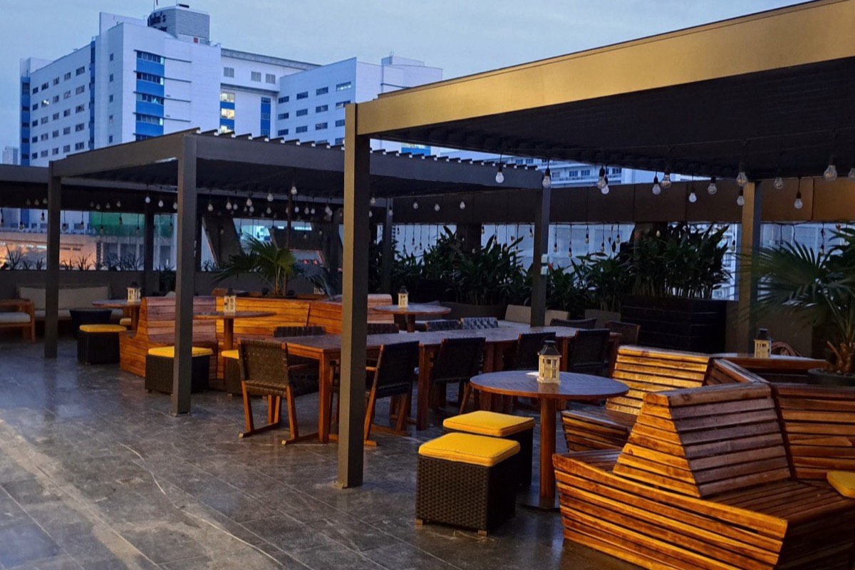 Terrasse en rooftop aménagée en fin de journée, vue sur la ville